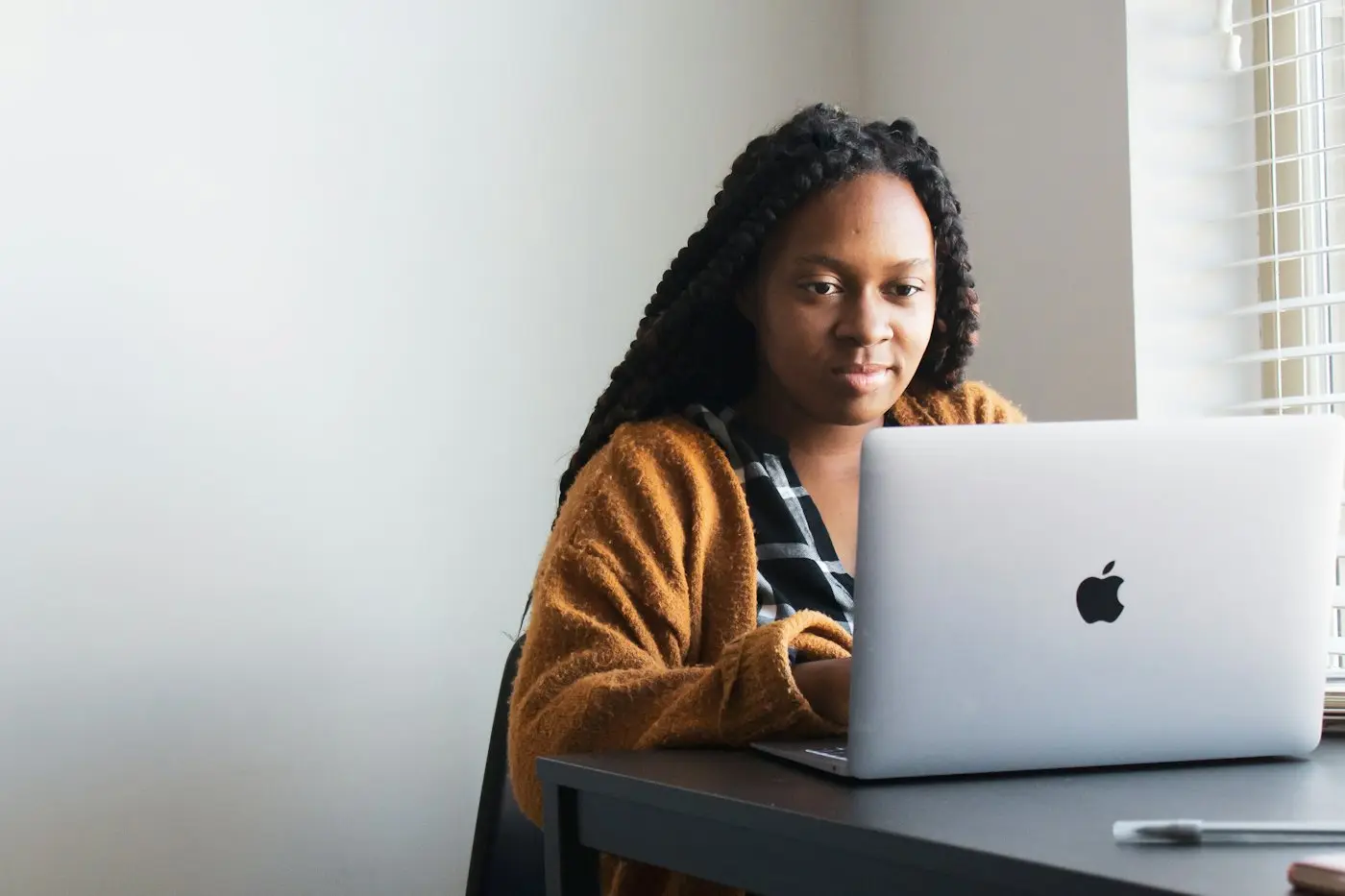 A woman working on a laptop at her desk